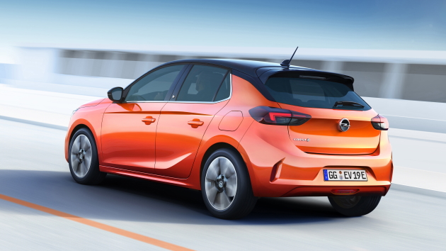 Opel Corsa-e orange heck hinten auf straße fahrend